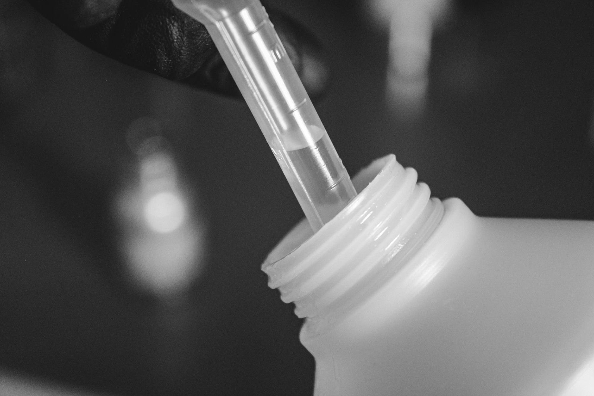 A pipette drawing liquid from a bottle